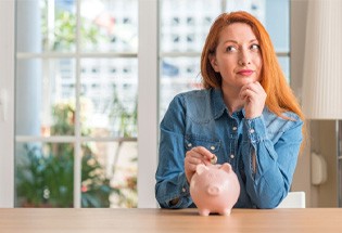 Woman putting coin in piggy bank 