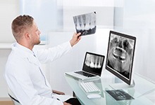 dentist looking at dental X-rays 