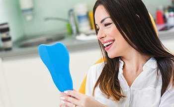 Female dental patient checking her smile in a mirror