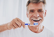 man brushing his teeth 