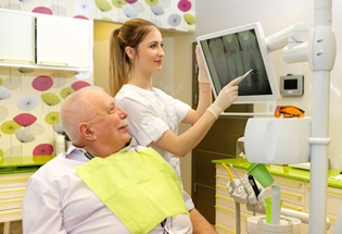 Dentist explaining dental implant care in San Antonio to patient