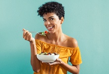 Woman eating salad and smiling