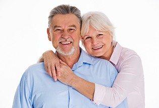 Older couple smiling together with arms around each other