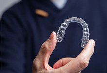 Closeup of patient holding Invisalign aligner 