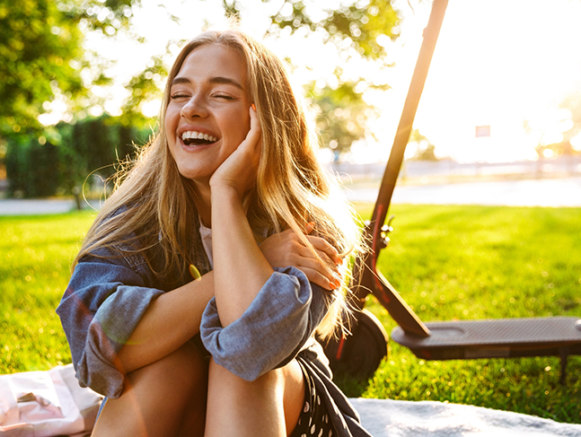 Blonde girl sitting outdoors in the sun