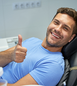 Young man giving a thumbs up in the dental chair