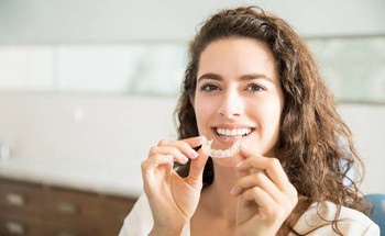 woman holding clear aligner