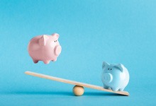 Piggy banks on balance scale