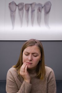 Woman in pain at emergency dentist in San Antonio.