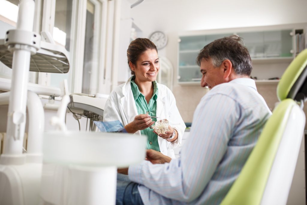 Dentist talking to patient about dental implants