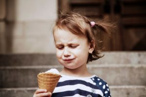 a little girl not eating ice cream because of tooth sensitivity